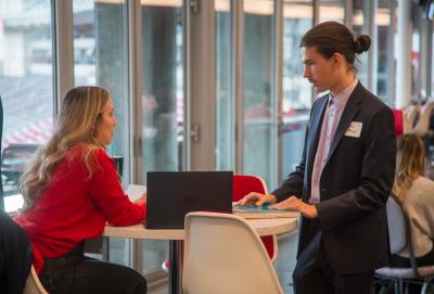 A career coach meeting with a student during a networking event.