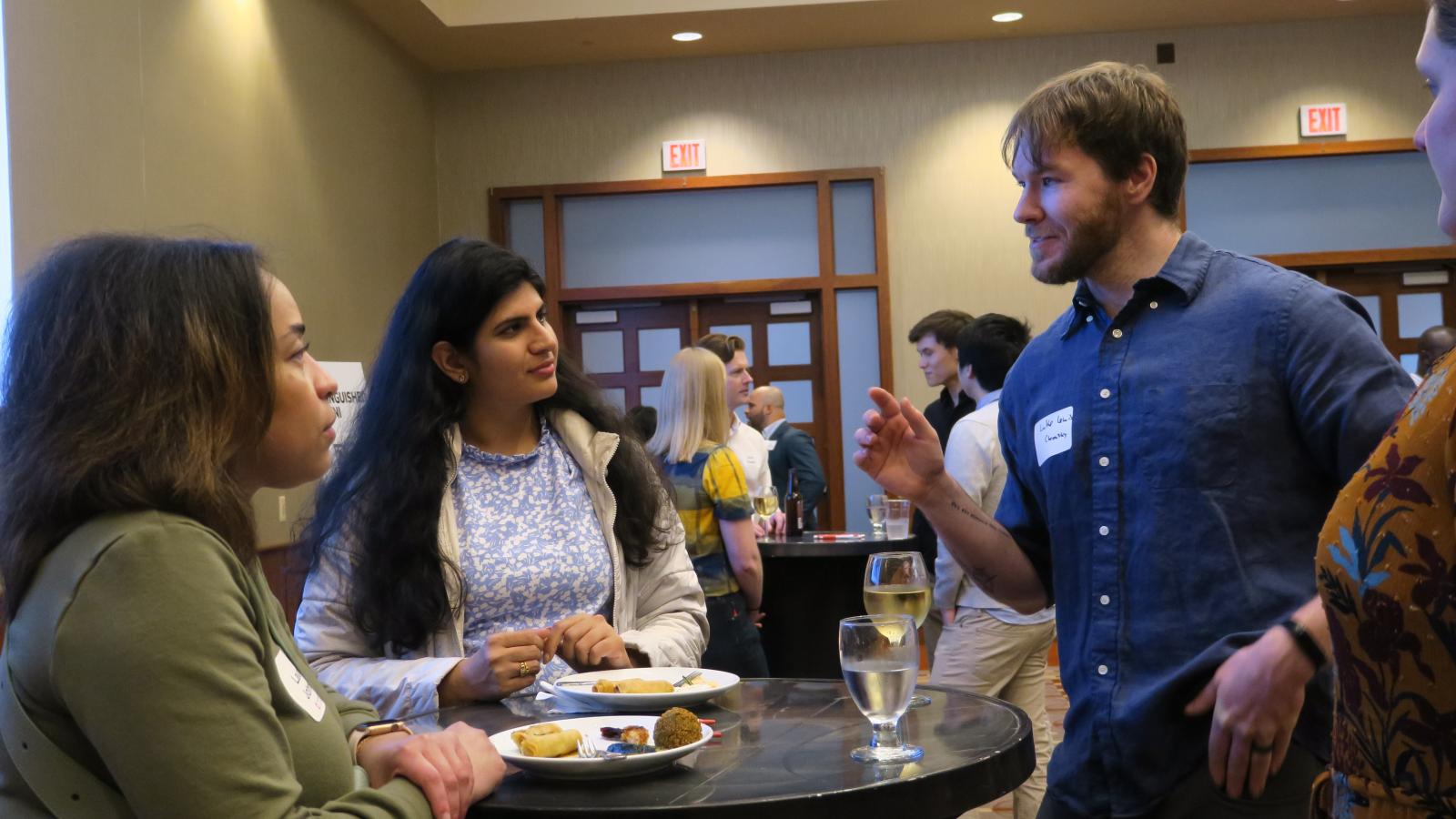 Students talking at a networking event. 